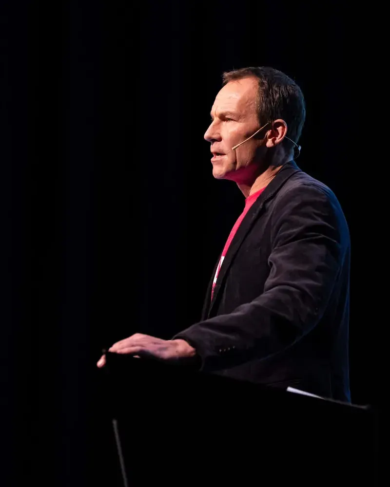Egil Winje Nybakk speaking on a dark stage